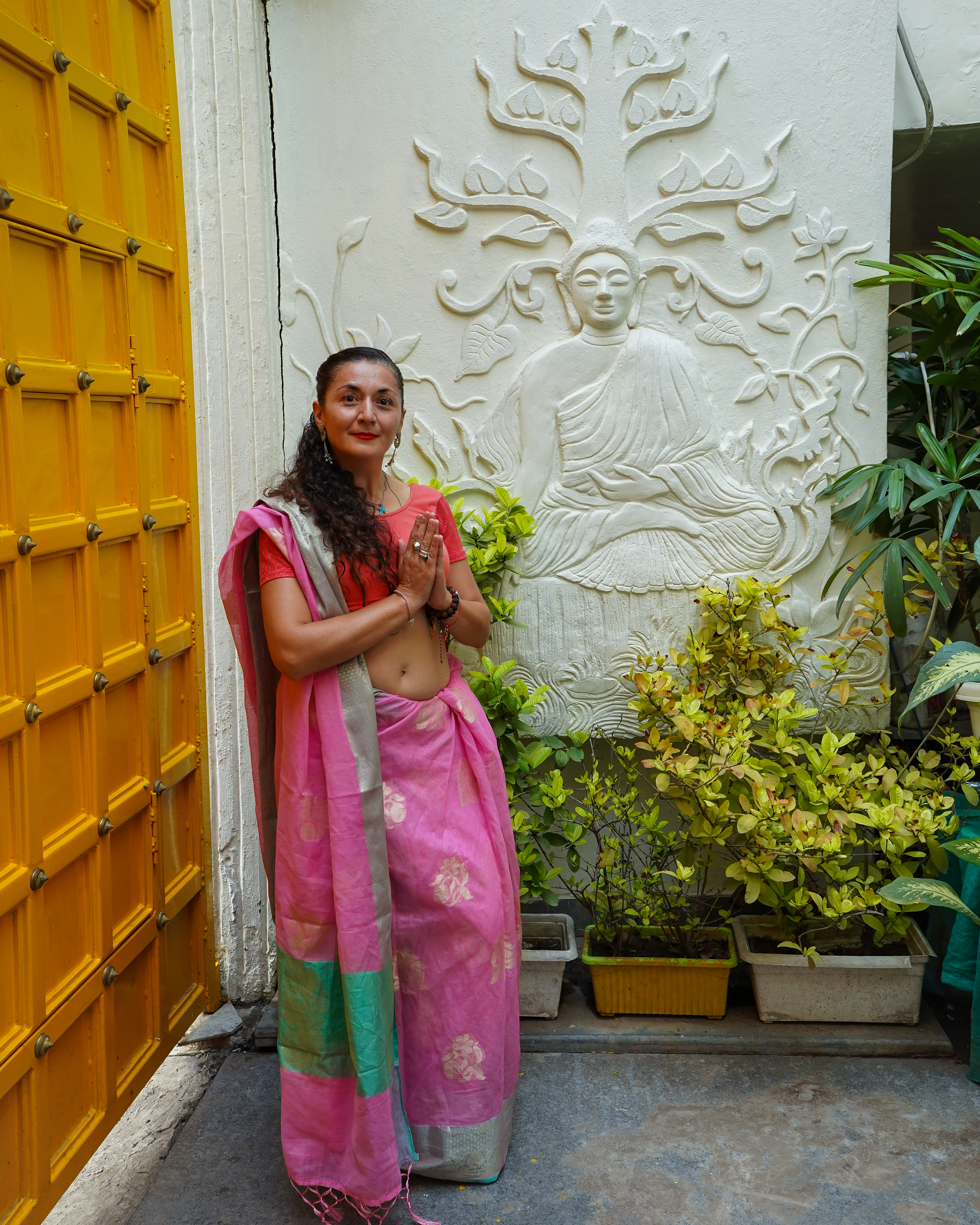 During the best season to visit Varanasi, a woman welcomes guests at the entrance of Stay Banaras boutique hotel.
